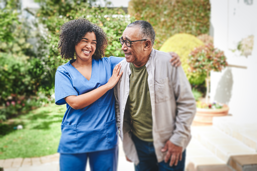 A female nurse smiling at an elderly resident.