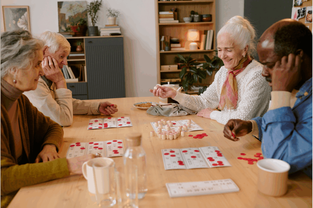 A group of four elderly individuals sit playing a game of bingo.